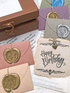 there are many different types of birthday cards on the table, including one with a wax stamp