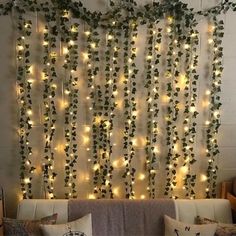 a living room filled with lots of lights and greenery hanging on the side of the wall