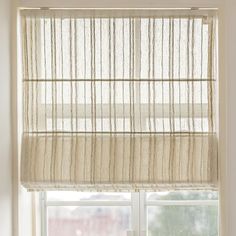 a window with a white curtain hanging from it's side next to a window sill