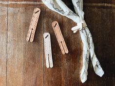 three pieces of wood are laying on the floor next to some clothes pins and a scarf