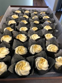 an open box filled with cupcakes covered in frosting