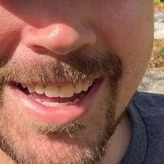 a close up of a man with a cell phone to his ear and wearing a hat