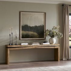 a living room with a large painting on the wall next to a table and candles