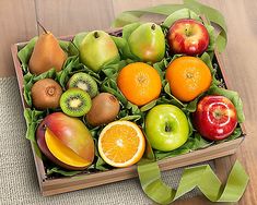 an open box filled with lots of different types of fruit on top of a wooden table