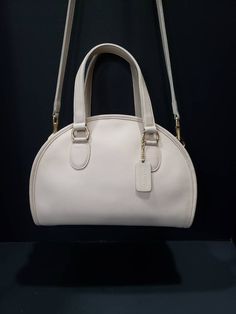 "For your consideration is this beautiful vintage Coach Chadwick Bag, or Bowler (style #9928) in Bone or ivory-white, with brass hardware. It is a \"Leatherware Era\" bag, and was made in the United Sates before 1994. It is in near Mint restored condition. I consider this bag to be the Grail of vintage Coach purses, and is one of the most beautiful bags that Coach made during this era. It is my favorite, and especially rare in bone. The Chadwick satchel is a unique Coach style that is sought aft Timeless Cream Satchel For Formal Use, Vintage White Top Handle Shoulder Bag, Classic Cream Satchel For Formal Occasions, Vintage White Bag With Detachable Handle, Vintage Cream Shoulder Bag With Detachable Strap, Vintage Beige Satchel With Top Carry Handle, Vintage White Handheld Shoulder Bag, Vintage Cream Bags With Detachable Handle, Vintage Cream Shoulder Bag With Detachable Handle