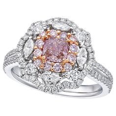 a pink and white diamond ring with two rows of diamonds around it