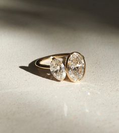 two diamond rings sitting on top of a table