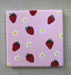 a pink canvas with strawberries and daisies on it