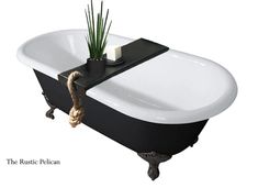 a black and white bath tub sitting next to a potted plant on top of it