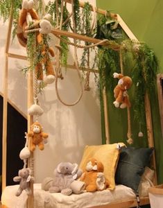 stuffed animals are hanging from a wooden bed frame