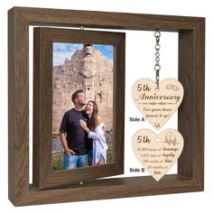 an anniversary photo frame with two hearts hanging from the front, and a key chain attached to it