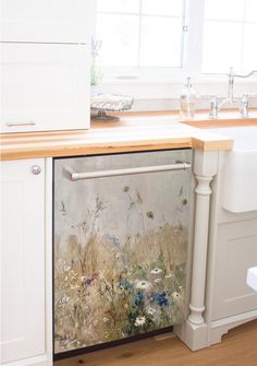 an open dishwasher sitting on top of a kitchen counter next to a sink