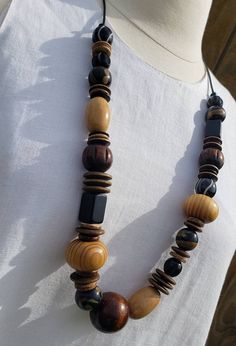 A variety of wooden beads styled together on a leather cord creating a bold and unique statement piece.  Necklace is approximately 32 inches long.  Every purchase is packaged for gift giving. Artisan Necklace With Brown And Black Beads, Brown Wooden Beads Long Necklace, Brown Long Beaded Necklace With Wooden Beads, Long Brown Beaded Necklace With Wooden Beads, Everyday Brown Wooden Beaded Necklaces, Adjustable Brown Long Necklace With Large Beads, Men Jewelry, African Jewelry, Beaded Necklaces