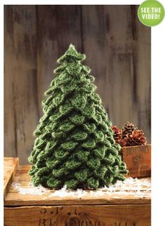 a small green christmas tree sitting on top of a wooden table