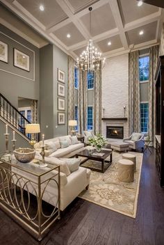 a living room filled with furniture and a fire place next to a stair case in front of a window