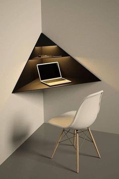 a laptop computer sitting on top of a desk under a triangular shaped shelf above a chair