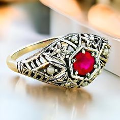 Discover a stunning piece of elegance with our Vintage Natural Ruby and Freshwater Pearl Accent Filigree Ring, meticulously crafted to elevate your jewelry collection. This exquisite ring features a vibrant, deep red natural ruby, surrounded by dainty freshwater pearls that gently complement its allure. Each ring is expertly crafted in quality 925 solid sterling silver, ensuring a timeless piece that shines with sophistication. The intricate filigree design showcases the artistry and attention to detail that defines exceptional vintage jewelry, making it a perfect choice for both everyday wear and special occasions. Whether you're dressing up for a night out or adding a touch of glamour to a casual outfit, this unique ring will surely draw admiration. To maintain its brilliant shine and be Victorian Pearl Ring Gemstone Gift, Victorian Pearl Ring With Gemstone For Gift, Exquisite Sterling Silver Diamond Ring With Gemstone, Victorian Pearl Ring Gift, Formal Silver Birthstone Ring With Accent Stones, Victorian Style Pearl Ring Gift, Vintage Pearl Ring With Gemstone, Formal Sterling Silver Birthstone Ring, Formal Sterling Silver Birthstone Ring With Accent Stones