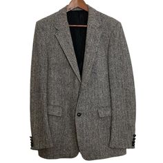 This vintage Eames blazer is in great condition! A classic blazer that features:   notch lapel  single breast  2 button front  3 button sleeve single vent  fully lined and structured  retro black buttons   100% wool by Harris Tweed, handwoven in Scotland Gray black herringbone pattern no size tag can suit a 40L See pics for measurements. Condition note: inside pocket has some debris on the lining, see pics Formal Tweed Sport Coat With Notch Lapel, Classic Tweed Blazer For Business Casual, Tweed Blazer With Hidden Button Closure And Notch Lapel, Classic Tweed Blazer With Suit Collar, Classic Business Blazer With Herringbone Pattern, Tailored Business Blazer With Herringbone Pattern, Classic Herringbone Blazer For Business, Classic Herringbone Pattern Blazer For Business, Tweed Blazer With Double Button For Business Casual