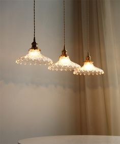 three lights hanging over a table in a room