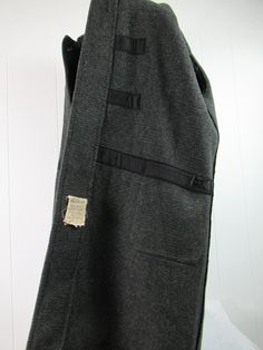 "Vintage 1950s 60s duffle coat, hooded toggle coat. Made of charcoal gray wool. Classic styling. Has hood, two pockets, chinstrap, wood and leather closures. Made in England. Size XL. Actual measurements are: 54\" around the chest 56\" around the waist 21.5\" shoulder seam to shoulder seam 25\" shoulder seam to cuff 40\" overall length(not including hood) In very good condition with some minor wear to lining trim." 1960s Coat, Toggle Coat, Duffle Coat, Vintage Coat, Hooded Coat, Charcoal Gray, Vintage 1950s, Charcoal Grey, Vintage Clothing