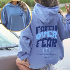 Introducing our inspiring "Faith Over Fear" hoodie, designed to uplift and encourage. This cozy hoodie features a meaningful symbol on the front, representing "God Is Greater than the Highs and Lows," reminding you of God's constant presence in every situation. On the back, the empowering phrase "Faith Over Fear" is paired with Psalm 34:4: "I sought the Lord, and he answered me; he delivered me from all my fears." Wear this hoodie to stay warm and share a message of faith, courage, and divine re Inspirational Hoodie For Fall Streetwear, Inspirational Fall Streetwear Hoodie, Inspirational Letter Print Hoodie For Fall, Inspirational Hooded Sweatshirt For Fall, Inspirational Hooded Fall Sweatshirt, Inspirational Hoodie Sweatshirt For Fall, Inspirational Fall Hoodie Sweatshirt, Inspirational Graphic Print Hoodie For Fall, Inspirational Long Sleeve Hoodie For Fall