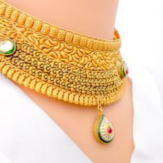 This magnificent choker set, crafted from 22k gold with an antique finish, weighs 69.1 grams. It showcases opulent paisley motifs accented with Kundan stones. The necklace is 14.5 inches long and 1.5 inches wide, featuring a drop length of 0.9 inches, creating a statement of refined elegance. With 1 inch of adjustable links, it ensures a perfect fit, secured by a hook lock. The set includes matching earrings, each 3 inches in length, equipped with screw-back posts for secure wear. This ensemble Gold Meenakari Kundan Necklace In 22k Gold, Gold 22k Meenakari Kundan Necklace, Heavy Gold Kundan Necklace For Formal Occasions, Ornate Kundan Necklace In 22k Yellow Gold, Formal Meenakari Temple Necklace In Gold Plated, Formal Gold Plated Meenakari Temple Necklace, Formal Gold-plated Meenakari Temple Necklace, Ornate 22k Yellow Gold Kundan Necklace, Formal Kundan Choker With Intricate Design