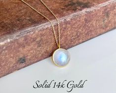 Rainbow Moonstone Necklace, Solid 14k Gold Pendant, June Birthstone, Real Gold Moonstone Jewelry , Birthday gift for her, Mother's Day Gift This classic minimalist necklace features a stunningly perfect flashy rainbow moonstone round puffy pendant bezeled in solid 14k gold. The blue flash moonstone pendant is suspended from a dainty solid 14k gold cable chain that come with 3 built-in adjustments to take this necklace to 16, 17 or 18 inches, whenever you needed.  Some pictures are magnified to show details, please read full description for accurate measurements, as well as all pictures on the model and the video provided. All elements of this necklace are 100% SOLID Gold. They will never tarnish or give an allergic reaction.  About this Necklace:  - Gemstone: Rainbow Moonstone - Birthstone Gold Moonstone Necklaces For Anniversary, Gold Moonstone Necklace For Anniversary, Dainty Moonstone Necklace For Anniversary, Minimalist Moonstone Necklace For Anniversary, Moonstone Round Pendant Jewelry For Anniversary, Moonstone Round Necklace For Gifts, Moonstone Round Necklace For Anniversary, Anniversary Jewelry With Moonstone Birthstone, Anniversary Moonstone Birthstone Jewelry