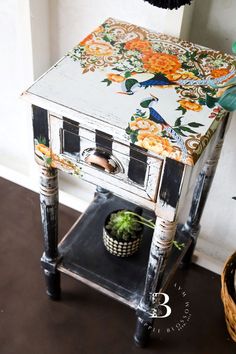 an old wooden table with flowers painted on it and a potted succulent