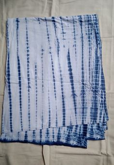 two blue and white tie - dyed towels laying on top of each other