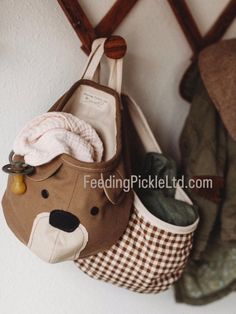 two purses hanging on the wall next to each other with stuffed animals in them