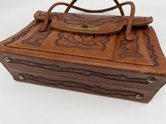 a brown leather purse sitting on top of a white table