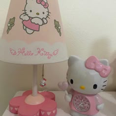 a hello kitty lamp next to a pink clock