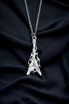 Calling all music lovers! Strike a chord with our Fire Electro Guitar Necklace. This one-of-a-kind piece is not just a necklace, but a statement of your passion and love for music. Perfect for both men and women, it's a versatile accessory that can add a rock-and-roll edge to any outfit. The pendant, a silver-plated fire electro guitar, is meticulously crafted with an eye for detail. It's a mini masterpiece that captures the spirit of music and the thrill of live performances. The pendant comes Silver Music-themed Metal Jewelry, Music-themed Silver Metal Jewelry, Music-themed Metal Jewelry For Gifts, Nickel-free Silver Jewelry For Concerts, Silver Music-themed Metal Necklace, Adjustable Music-themed Jewelry For Concerts, Adjustable Silver Jewelry For Concert, Adjustable Silver Jewelry For Concerts, Nickel-free Music-themed Jewelry For Concerts