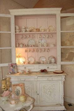 an old china cabinet with dishes on it