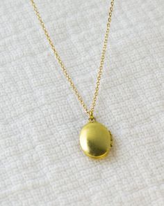 Mini Locket Necklace Oval Brass Tiny Locket Jewelry | Etsy Dainty Oval Jewelry With Adjustable Chain, Oval Locket Jewelry For Everyday, Minimalist Jewelry With Oval Locket Pendant, Vintage Charm Oval Link Necklace As Gift, Oval Link Necklaces With Vintage Charm For Gifts, Vintage Jewelry With Delicate Chain For Everyday, Adjustable Gold Locket Charm Necklaces, Adjustable Gold Locket Charm Necklace, Adjustable Gold Charm Necklaces With Locket