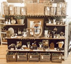 an old fashioned store display with lots of items on shelves and wooden crates in front of it