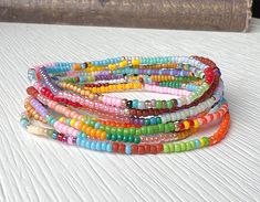 Colorful seed bead color block bracelet.   Each is unique and different and the photos show a representative sample of the bracelets you will receive * Choose a stack of 3, 5, or 10 bracelets * Made from tiny glass seed beads  * Beads are size 11 or 2mm  * Available in 5 sizes * Strung on durable beading elastic. 🦋 YOU MAY ALSO LIKE Daisy & Dahlia Bracelets https://etsy.me/4855PlF Our best selling items https://bit.ly/3QxR70G Tila Bracelets- https://etsy.me/3phAFHw 🦋 FIND THE PERFECT FIT * Measure all the way around your wrist with a tape measure or string  * For a snug fit choose your exact size  * For a looser fit go up a size  * If you're between sizes, choose the larger of the two sizes * Bracelets will soften and stretch slightly over time * If you are purchasing  a gift and you are Multicolor Beaded Bracelets With Letter Beads, Multicolor Tiny Beads Necklace For Friendship, Multicolor Round Beaded Bracelets With Letter Beads, Colorful Friendship Bracelets With Tiny Round Beads, Rainbow Heishi Beads Bracelets For Jewelry Making, Multicolor Multi-strand Beaded Bracelets For Beach, Colorful Beads Multi-strand Friendship Bracelets, Colorful Multi-strand Friendship Bracelets As Gift, Colorful Multi-strand Friendship Bracelets