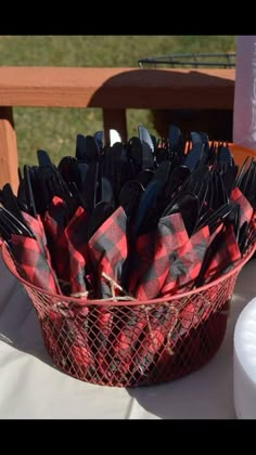 a basket filled with black and red napkins sitting on top of a white table