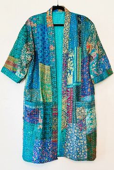 This delightful kimono is a breath of fresh air. A full kaleidoscope of bright colors like a blooming spring garden. Constructed with high quality cotton, handmade and kantha embroidered. Designed as a traditional short kimono with an extra wide front band showcasing kantha embroidery created by hand. This embroidery is also carried throughout the garment. Special detailing is noticable throughout the garment, double width hem panel, etc. The bright color pallet works well with most skin tones. Bright Color Pallets, Layer Jacket, Women Tunic, Kantha Embroidery, Pastel Print, A Breath Of Fresh Air, Cotton Kimono, Short Kimono, Women Tunic Tops