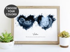 an image of two babys in the shape of hearts on a white wall next to a potted plant