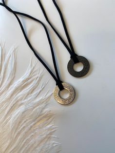 This Muslim men's necklace features a finely crafted pendant showcasing the Shahada, the Islamic declaration of faith. The pendant is made from high-quality materials, such as stainless steel, ensuring durability and a polished finish. The Shahada is intricately embossed, adding a touch of elegance to the piece. The necklace itself is designed with meticulous attention to detail, incorporating traditional Islamic elements into the leather cord. This accessory serves as a meaningful and stylish expression of religious identity for the wearer. Symbolic Black Etched Jewelry, Symbolic Necklace With Oxidized Finish And Adjustable Fit, Symbolic Adjustable Necklace With Oxidized Finish, Symbolic Necklace With Oxidized Finish, Black Spiritual Jewelry With Coin Pendant, Spiritual Black Coin Pendant Jewelry, Black Amulet Necklace With Coin Pendant, Adjustable Amulet Necklace With Oxidized Finish, Adjustable Medallion Necklace With Oxidized Finish