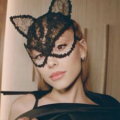 a woman wearing a black cat mask with lace on it's ears and nose