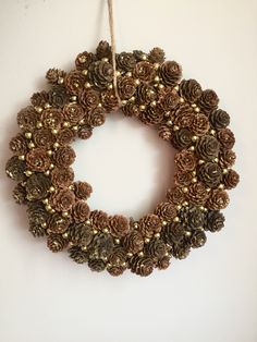 a wreath made out of pine cones hanging on a wall