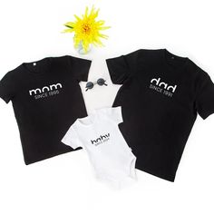 Celebrate family with this personalized matching shirt set featuring custom birth years for mom, dad, and baby. Perfect for birthdays, Mother's Day, Father's Day, and special family occasions.Introducing the Custom Birth Year Family Matching Shirt Set - a heartwarming and stylish gift that celebrates the unique bond between parents and their little one. This set includes three pieces: a 'mom' shirt, a 'dad' shirt, and a 'baby' bodysuit, each personalized with the respective birth years, creating Personalized Family Matching T-shirt For Summer, Personalized Family T-shirt For Summer, Custom Text Cotton Tops For Family Events, Family Matching T-shirts With Custom Text For Family Events, Matching Family Personalized T-shirts, Father's Day Personalized Matching T-shirt, Personalized Matching Crew Neck T-shirt, Family Matching T-shirt For Father's Day With Custom Text, Personalized T-shirt For Family Events On Mother's Day