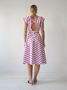 "Vintage 80's chevron striped sundress. Adjustable tie at waist. Open back with buttons down lower back. Full skirt. Lightweight cotton material. - - M E A S U R E M E N T S - - Fits like: xs/small Bust: 17\" Waist: 13\"-adjustable smaller Length: 44\" Hips: open Shoulder: 14.5\" Fabric: cotton In excellent condition - no flaws to note. ● Model is 5'7\" / bust: 34\" / waist: 25\" / hips: 37\"" Striped Cotton Summer Sundress, Cotton Summer Dress With Vertical Stripes, Pink Vertical Stripe Summer Dress, Pink Vertical Striped Summer Dress, Striped Fitted Sundress For Summer, Fitted Striped Sundress For Summer, Striped Fitted Midi Sundress, Vintage Striped Summer Dresses, Fitted Summer Dress With Vertical Stripes