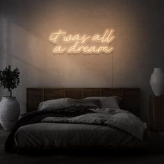 there is a neon sign above the bed that says, it's all dream