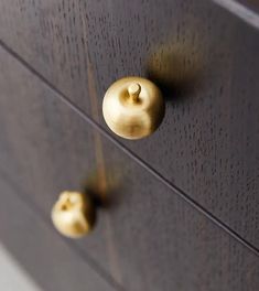 two brass knobs on the handles of a dresser