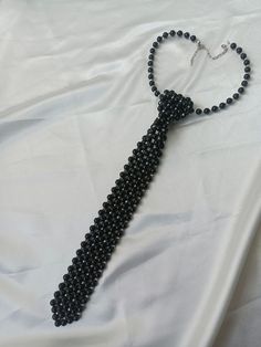 "Black Pearl Neck Tie Faux Pearl Necklace, unique statement for you" Step into sophistication with our exquisite Black Pearl Tie adorned with shimmering silver beads. Crafted with meticulous attention to detail, each tie is a testament to timeless elegance and impeccable craftsmanship. **Perfect for special occasions or adding a touch of glamour to everyday attire, our Black Pearl Tie is sure to turn heads and make a statement wherever you go. #Embrace the allure of understated luxury and elevat Elegant Beaded Necklace For Party, Elegant Black Beaded Necklaces For Evening, Elegant Black Beaded Necklace For Evening, Evening Black Beaded Necklaces, Elegant Black Beaded Necklace For Evenings, Elegant Black Beaded Necklaces, Adjustable Black Beads Necklace For Party, Adjustable Black Beaded Necklaces For Party, Adjustable Black Beaded Necklace For Party