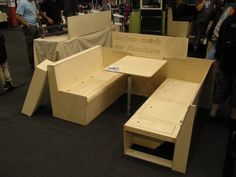 several people are looking at furniture made out of plywood and cardboard boxes on display