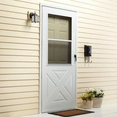 a white front door on a house with potted plants